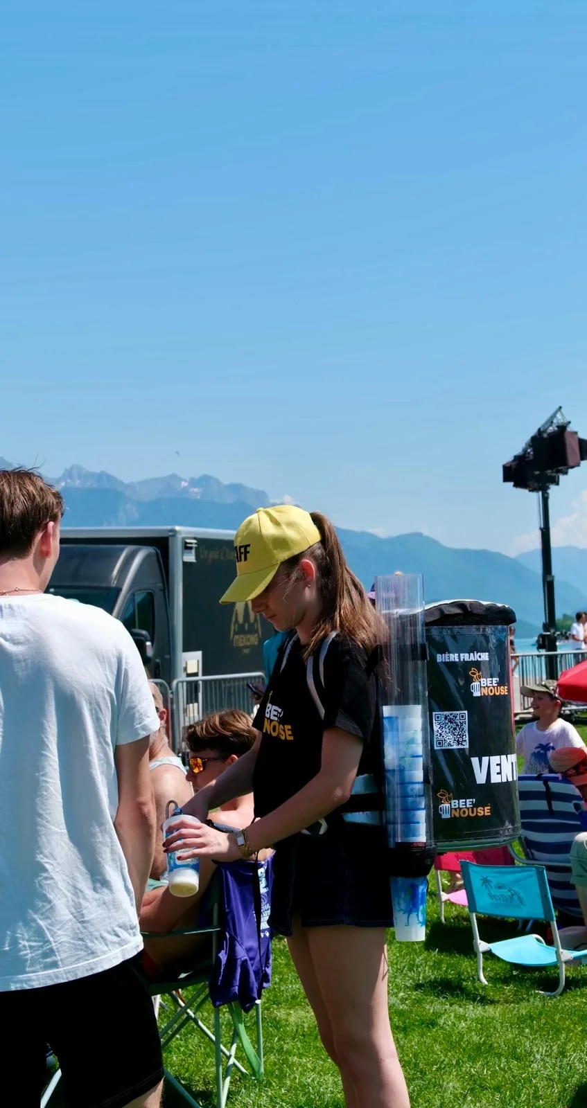 Une opératrice Bee’Nouse sert une boisson au public avec un équipement mobile clairement visible